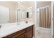Bright bathroom features a vanity with sink, large mirror, and a shower/tub combination with neutral tiling at 12030 W Polk St, Avondale, AZ 85323