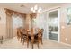 Cozy dining room features an elegant chandelier and a sliding glass door to the patio at 12030 W Polk St, Avondale, AZ 85323