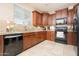 Functional kitchen features granite countertops, rich wood cabinets, and black appliances at 12030 W Polk St, Avondale, AZ 85323