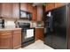 Efficient kitchen design with wooden cabinetry, granite countertops, and black appliances for modern convenience at 12030 W Polk St, Avondale, AZ 85323