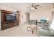 Spacious living room featuring neutral carpet, sofa, loveseat, ceiling fan, and staircase to the upper level at 12030 W Polk St, Avondale, AZ 85323
