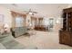 Open living and dining area with neutral walls and carpet, ceiling fan and sliding glass door to the patio at 12030 W Polk St, Avondale, AZ 85323