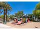 Colorful community playground with slides and climbing structures surrounded by mature trees at 12030 W Polk St, Avondale, AZ 85323