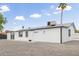 Exterior shot of a home's backyard featuring desert landscaping, white stucco walls, dark trim and a grey roof at 13202 N 40Th Pl, Phoenix, AZ 85032