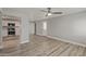 Bright living room with modern ceiling fan, grey walls, and wood-look flooring, open to the kitchen at 13202 N 40Th Pl, Phoenix, AZ 85032