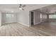 Spacious living room with grey walls, wood-look flooring, a ceiling fan, and ample natural light at 13202 N 40Th Pl, Phoenix, AZ 85032