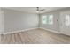 Open-concept living room with wood-look flooring, white door, and a bright window at 13202 N 40Th Pl, Phoenix, AZ 85032
