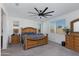 Large main bedroom features a ceiling fan, two windows, and wooden furniture at 14188 W Artemisa Ave, Surprise, AZ 85387