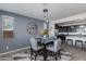 Cozy dining area with modern table, chairs, pendant lighting, and view into the kitchen at 14188 W Artemisa Ave, Surprise, AZ 85387