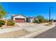 Well-maintained home with a red garage door, desert landscaping, and a tidy driveway under a clear blue sky at 14188 W Artemisa Ave, Surprise, AZ 85387