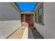 Inviting front entrance with a red door, desert landscaping, and a covered walkway leading to the main entrance at 14188 W Artemisa Ave, Surprise, AZ 85387