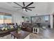 Open-concept living room with a dining area, modern ceiling fan, and stylish decor at 14188 W Artemisa Ave, Surprise, AZ 85387