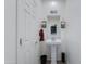 Neat powder room with a pedestal sink, decorative mirror, and white painted walls at 14188 W Artemisa Ave, Surprise, AZ 85387