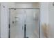 Bright bathroom featuring a spacious glass enclosed shower with seat and shampoo shelf at 14188 W Artemisa Ave, Surprise, AZ 85387
