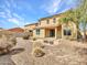Exterior view of the house showing the backyard with gravel and a stone patio with fire pit at 15093 W Glenrosa Ave, Goodyear, AZ 85395