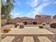 Cozy backyard featuring a stone patio with a charming fire pit and mature shrubbery at 15093 W Glenrosa Ave, Goodyear, AZ 85395