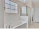 Bright bathroom featuring a tub and glass shower with a frosted grid window providing natural light at 15093 W Glenrosa Ave, Goodyear, AZ 85395