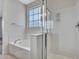 Bright bathroom featuring a tub and glass shower with a frosted grid window providing natural light at 15093 W Glenrosa Ave, Goodyear, AZ 85395