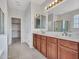 Bathroom view showcasing double sinks, vanity, lighting, and doors, all contributing to the bathroom's overall design at 15093 W Glenrosa Ave, Goodyear, AZ 85395