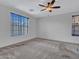 Large bedroom with neutral carpet features dual windows and a ceiling fan at 15093 W Glenrosa Ave, Goodyear, AZ 85395