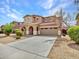 Charming two-story stucco home featuring a spacious driveway, arched entryway, and attached two-car garage at 15093 W Glenrosa Ave, Goodyear, AZ 85395