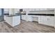 Bright kitchen featuring stainless steel appliances, dark countertops, white cabinets, and wood-look floors at 15093 W Glenrosa Ave, Goodyear, AZ 85395