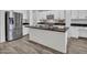 Modern kitchen featuring stainless steel appliances, dark countertops, white cabinets, and wood-look floors at 15093 W Glenrosa Ave, Goodyear, AZ 85395
