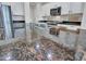 Kitchen island with dark countertop, stainless steel sink and faucet, and white cabinetry at 15093 W Glenrosa Ave, Goodyear, AZ 85395