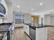 Open-concept kitchen featuring a kitchen island, stainless steel appliances, and wood-look floors at 15093 W Glenrosa Ave, Goodyear, AZ 85395