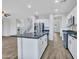 Open-concept kitchen featuring a kitchen island, stainless steel appliances, and wood-look floors at 15093 W Glenrosa Ave, Goodyear, AZ 85395