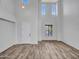Bright living room boasts high ceilings, numerous windows, and stylish wood-look flooring at 15093 W Glenrosa Ave, Goodyear, AZ 85395