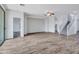 Open-concept living room featuring wood-look flooring, stair access, and natural light at 15093 W Glenrosa Ave, Goodyear, AZ 85395