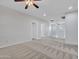 Expansive loft area featuring neutral walls, carpet, ceiling fans, a white railing, and natural light at 15093 W Glenrosa Ave, Goodyear, AZ 85395