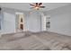 Spacious main bedroom with carpet features ceiling fan and open doorways to bathroom and kitchen at 15093 W Glenrosa Ave, Goodyear, AZ 85395