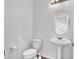 Elegant powder room with a pedestal sink, oval mirror, and modern fixtures at 15093 W Glenrosa Ave, Goodyear, AZ 85395