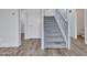 Carpeted staircase with white railings, hardwood floors, and white walls at 15093 W Glenrosa Ave, Goodyear, AZ 85395