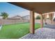 View of an outdoor patio with pillars, pavers, artificial turf and privacy walls with blue skies at dusk at 15155 W Desert Hills Dr, Surprise, AZ 85379