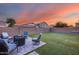 Backyard with artificial grass, desert landscaping, covered patio, and outdoor seating at 15155 W Desert Hills Dr, Surprise, AZ 85379