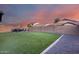 Large backyard with artificial turf, rock landscaping, covered seating area and perimeter block fence at 15155 W Desert Hills Dr, Surprise, AZ 85379