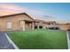 Large backyard featuring green artificial turf, desert rock landscaping and block fence at 15155 W Desert Hills Dr, Surprise, AZ 85379