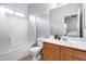 This bathroom has a shower and tub, a vanity with drawers and cabinets, and a white countertop at 15155 W Desert Hills Dr, Surprise, AZ 85379