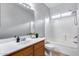 This bathroom includes a shower and tub combination with a white shower curtain and a vanity with sink at 15155 W Desert Hills Dr, Surprise, AZ 85379