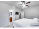 This gray-walled bedroom has a ceiling fan, ensuite bathroom, a TV mounted on the wall, and carpet at 15155 W Desert Hills Dr, Surprise, AZ 85379