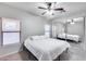 This bedroom has carpet, a ceiling fan, a large mirrored closet, and windows that provide natural light at 15155 W Desert Hills Dr, Surprise, AZ 85379