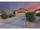 Beautiful single-story home featuring a well-maintained front yard and a two-car garage at dusk at 15155 W Desert Hills Dr, Surprise, AZ 85379