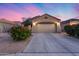 Charming single-story home featuring a well-maintained front yard and a two-car garage under a beautiful sky at 15155 W Desert Hills Dr, Surprise, AZ 85379