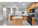 Well-lit kitchen featuring wood cabinets, an island, and open views into other living areas at 15155 W Desert Hills Dr, Surprise, AZ 85379