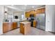 Functional kitchen featuring wooden cabinetry, stainless steel appliances, and an island for efficient food preparation at 15155 W Desert Hills Dr, Surprise, AZ 85379