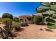 Desert landscaping featuring decorative gravel, lush trees and plants, complements the covered patio and outdoor space at 15936 W Clear Canyon Dr, Surprise, AZ 85374