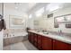 Bright bathroom featuring double vanity, soaking tub, and granite countertops at 15936 W Clear Canyon Dr, Surprise, AZ 85374